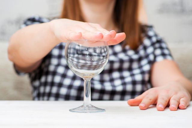 グラスを手でふさぐ女性